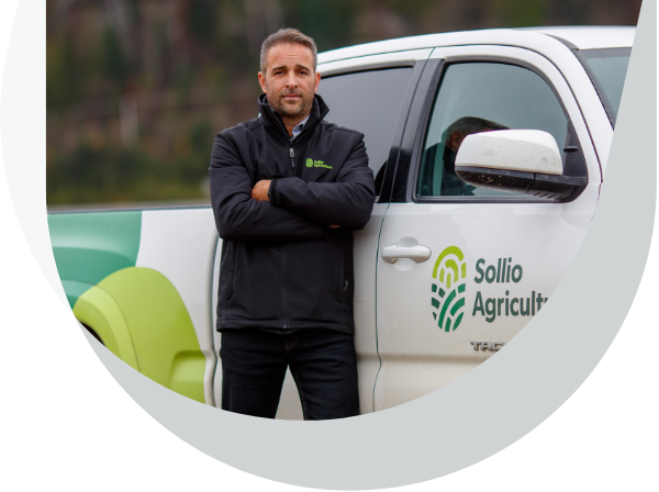 Un employé pose devant une camionnette aux couleurs de Sollio Agriculture. 