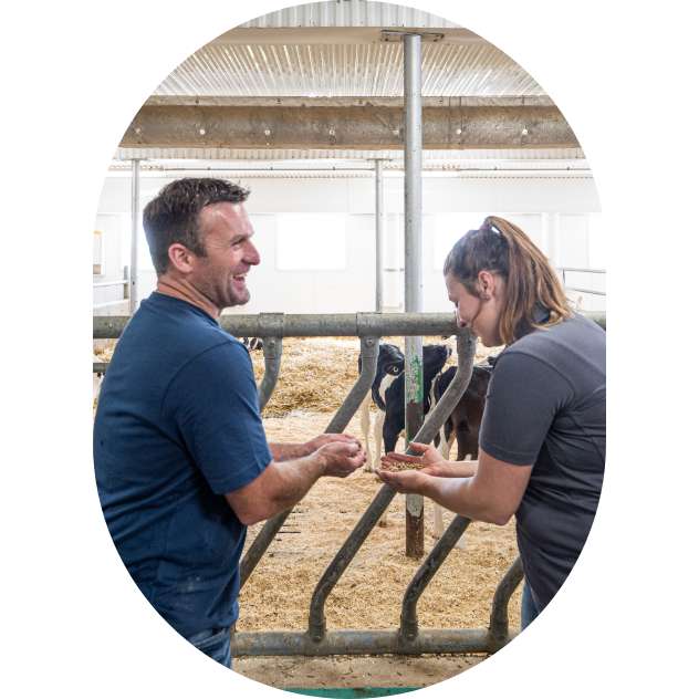 Un producteur laitier et une experte-conseil Sollio Agriculture dans une étable avec des génisses logées en hiver.