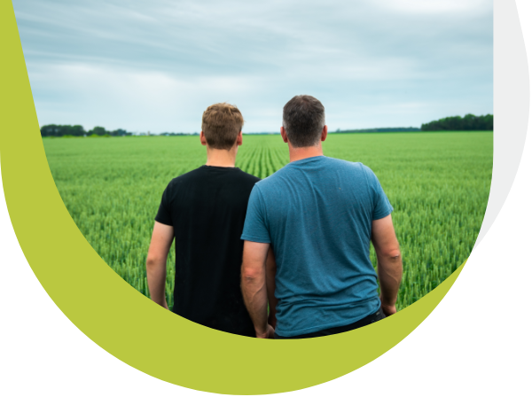 Two farmers from behind looking at their field.