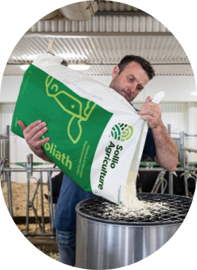 Un producteur qui ajoute le lactoremplaceur de la gamme Goliath de Sollio Agriculture dans une louve.
