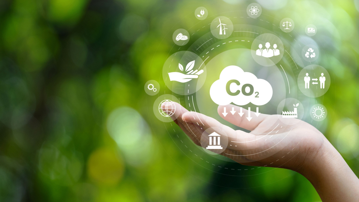 Une main tendue avec une illustration de CO2 et d'émission de GES au-dessus, dans un contexte agricole. 