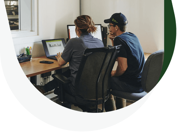 Two producers in front of a computer.