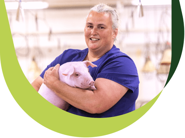 Une femme tient un cochon dans ses bras