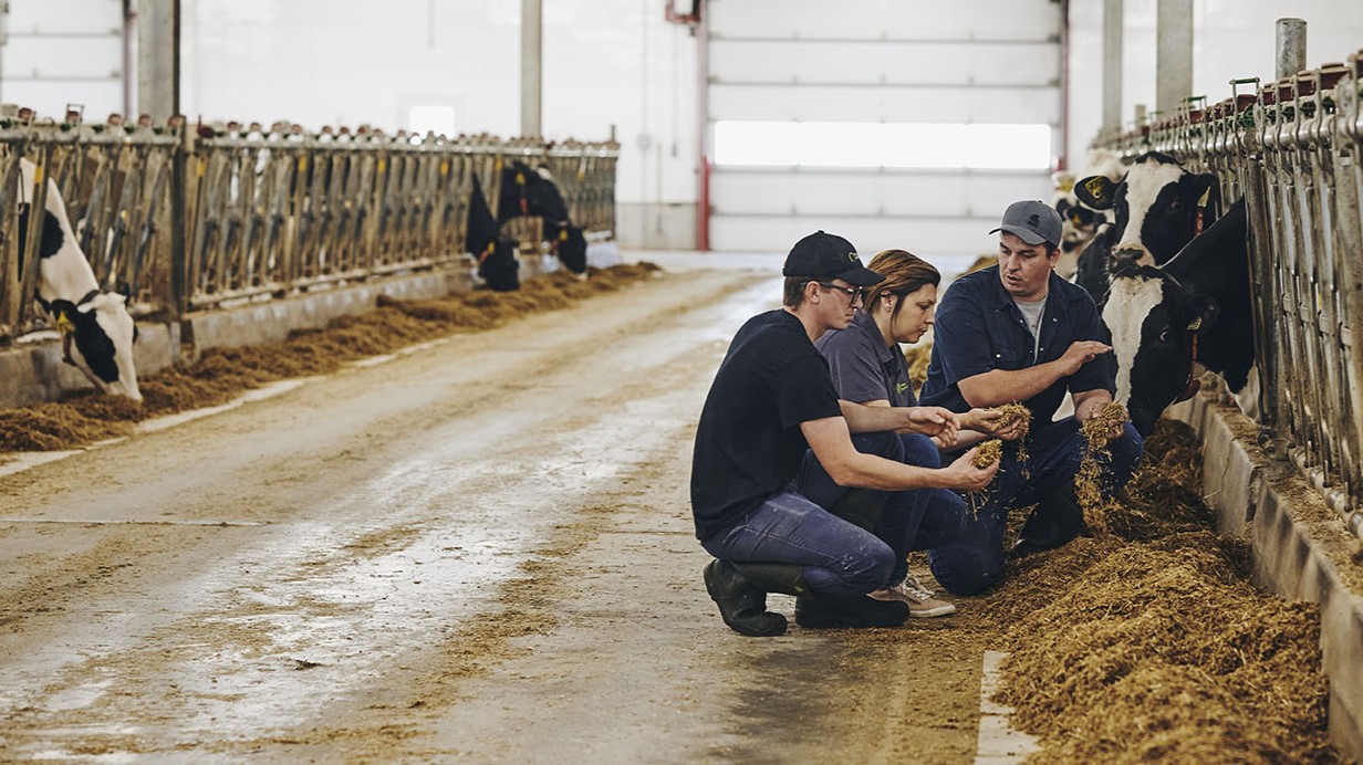 An expert-advisor discusses GHG reduction practices with two farmers