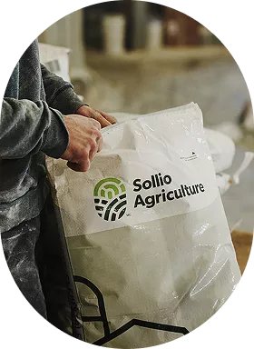 Un homme ouvre un sac où on voit le logo de Sollio Agriculture.